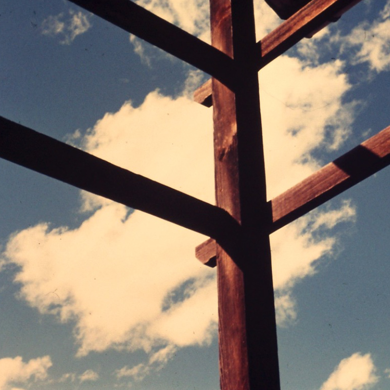 Immagine astratta con pali di legno e cielo con nuvole